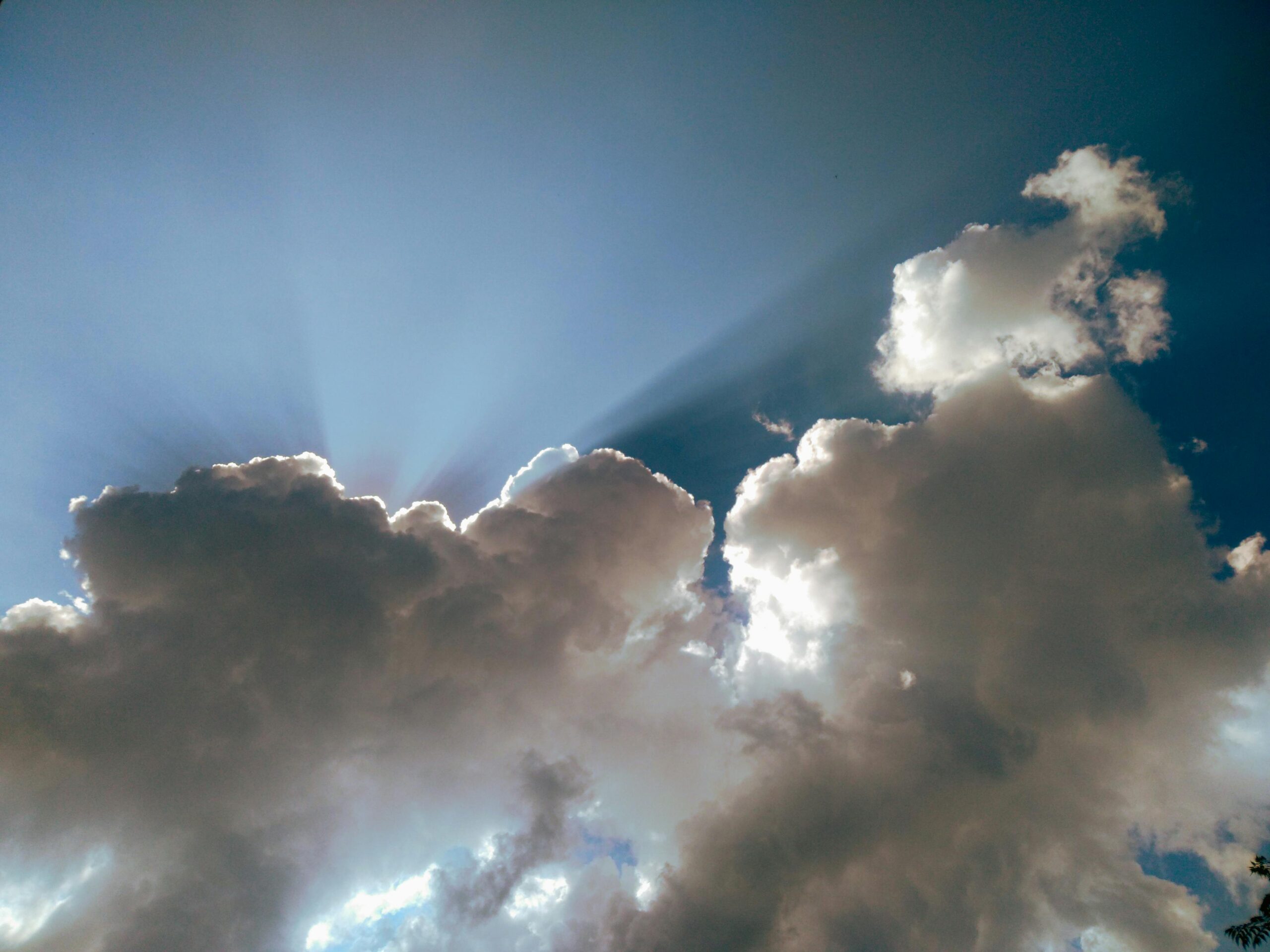 Serene cloudscape with sun rays peeking through clouds over Sangrur.